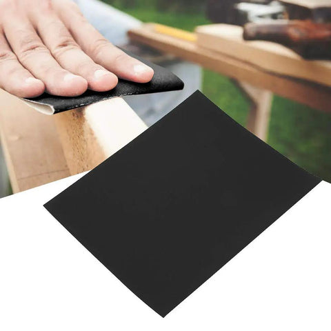 Top Tier 100 Piece Sandpaper Sheets For Woodworking Pros in use on wood surface for polishing with black aluminum oxide paper.