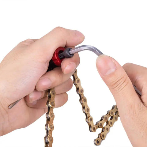 Hands using Mini Bike Chain Cutter Tool For Quick Pin Removal And Link Breaking, showing leverage with an Allen wrench.