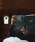 Manual LED Night Light With High Low Off Switch 20 Lumens Brightness Glare Free Warm White 3000K next to person reading