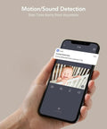 Hand holding a smartphone displaying 2K Baby Monitor With AI Motion Tracking Two Way Audio WiFi Indoor Camera app showing baby.