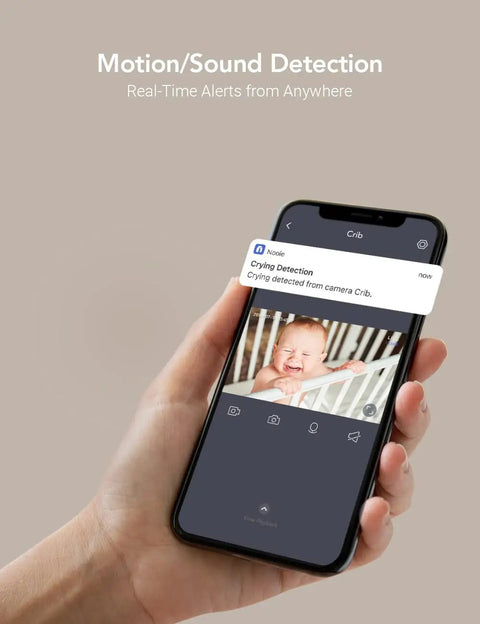 Hand holding a smartphone displaying 2K Baby Monitor With AI Motion Tracking Two Way Audio WiFi Indoor Camera app showing baby.