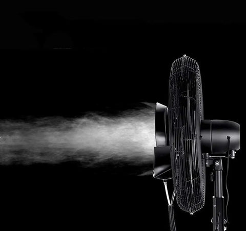 Heavy Duty Oscillating Mist Fan With Three Speed Levels And Adjustable Pedestal spraying fine mist in a dark setting.