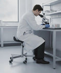 Heavy Duty Swivel Stool With Wheels Built From 304 Stainless Steel in lab, used for microscopy work by a scientist.