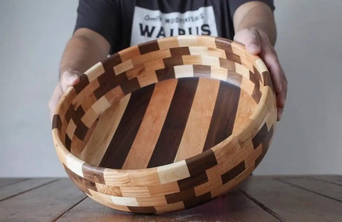 Person holding handmade wooden bowl with striped pattern, showcasing craftsmanship and design. Cutting Board Oil For Wood And Butcher Block, 32 Oz Jug, FDA Food Contact Safe, Food Grade Mineral Oil, Made In USA, Pro Kitchen Quality For Dark Wood, Non Toxic, Odorless Finish, Keeps Surfaces Sealed Like A Boss.