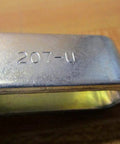 Close-up of 207 U Series Vertical Hold Down Clamp With Flanged Base showing model number on metal surface.