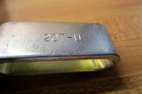 Close-up of 207 U Series Vertical Hold Down Clamp With Flanged Base showing model number on metal surface.