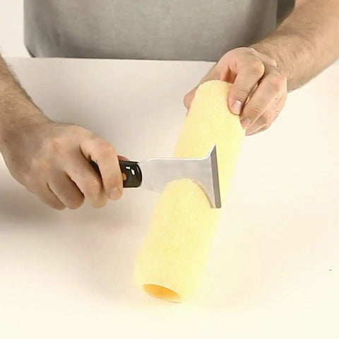 Person using Six In One Painter Tool For DIYers With Scraper, Putty Knife, Roller Cleaner, Nail Setter, Gouger And Spreader to clean roller