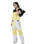 Model wearing yellow and white waterproof insulated ski bibs with black zippers, showcasing windproof adjustable snow overalls.