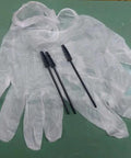 Disposable gloves and mascara brushes on a green surface