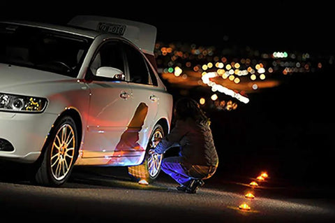 Person using Emergency LED Road Flare Kit Set Of 3 With Magnetic Base Beacons beside a car at night, roadside safety lights visible