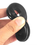 Kickass Heavy Duty Rubber Grommets For Wiring Harness Protection 2 Inch Inner Diameter Flame Retardant Heat Insulator Plug 4 Pack held in hand.