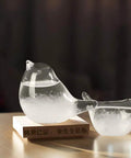 Bird-shaped storm glass weather forecaster on wooden base, high borosilicate, for home and office decor, weather gauge.