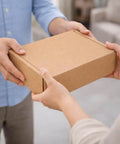 Rugged Corrugated Shipping Boxes 12x9x4 Inches Pack Of 60 Kraft Cardboard Mailers being exchanged between hands