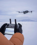 Person operating Mavic 4 Pro Drone With 100MP Hasselblad 4/3 CMOS Main Camera And Dual Tele Lenses, outdoor snow scene