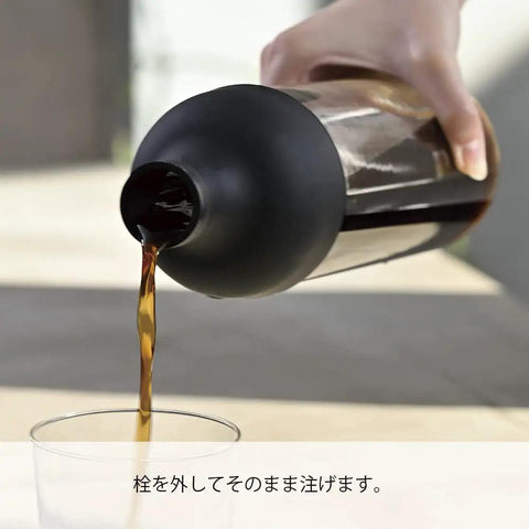 Pouring coffee from 650ml Cold Brew Coffee Bottle With Removable Filter Heatproof Glass No Fuss Pour Fridge Safe Black Finish.
