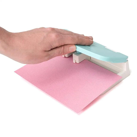Hand using Word Punch Board For Scrapbooking And Card Making Dope Letter Punch Set With 26 Letters, aligning pink paper.