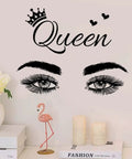 Queen wall decal with crown and eyes above books, candles, and flamingo decor on shelf