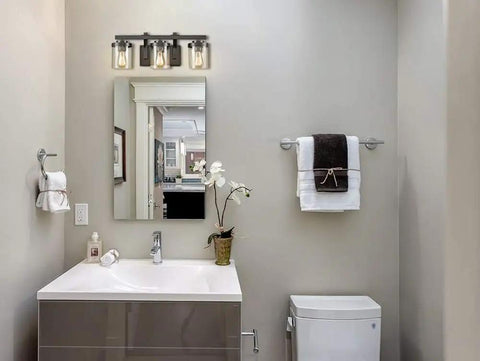 Oil Rubbed Bronze 3 Light Bathroom Vanity Light Fixture With Clear Glass Shades installed above bathroom mirror