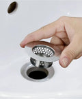Person holding a stainless steel hair strainer universal drain catcher for bathroom sinks, ideal for preventing clogs.