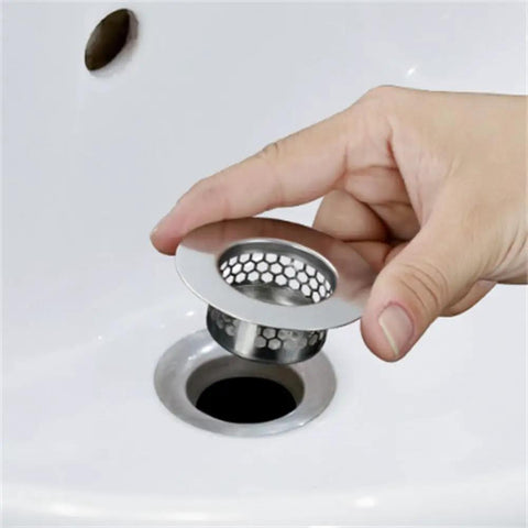 Person holding a stainless steel hair strainer universal drain catcher for bathroom sinks, ideal for preventing clogs.