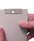 Close-up of a person holding a slat with Vertical Blind Repair Clips With Curved Vane Saver For Window Blinds No Fuss Tabs Fix Replacement Slats White 15 Pack For Easy DIY Window Treatment Upgrades.