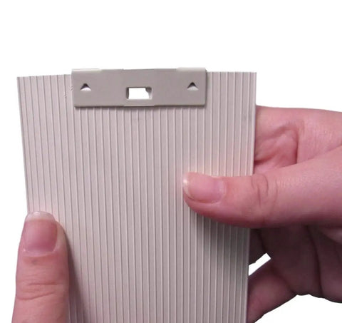 Close-up of a person holding a slat with Vertical Blind Repair Clips With Curved Vane Saver For Window Blinds No Fuss Tabs Fix Replacement Slats White 15 Pack For Easy DIY Window Treatment Upgrades.