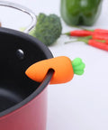 Heavy Duty Silicone Pot Lid Rack And Super Sturdy Cover Lifter Holder For Zero Spill Cooking with carrot design on pot.