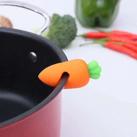 Heavy Duty Silicone Pot Lid Rack And Super Sturdy Cover Lifter Holder For Zero Spill Cooking with carrot design on pot.