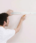 Person using Top Shelf Heavy Duty Stainless Steel L Square Ruler 90 Degree Layout Measuring Tool For Carpenters And Engineers With Dual Scale And Rust Resistant Finish to mark a wall.