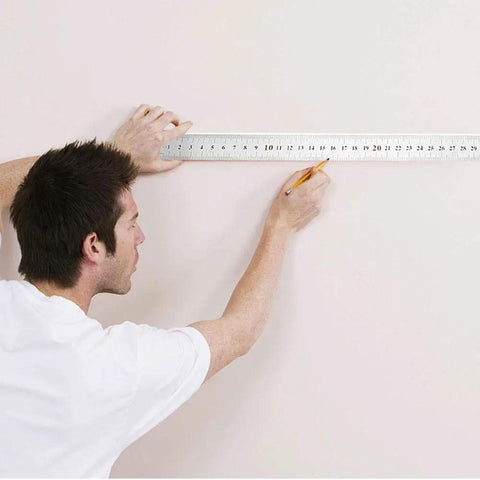 Person using Top Shelf Heavy Duty Stainless Steel L Square Ruler 90 Degree Layout Measuring Tool For Carpenters And Engineers With Dual Scale And Rust Resistant Finish to mark a wall.