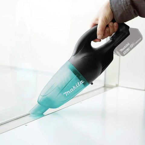 Hand using 18V LXT Cordless Vacuum With Redesigned Floor Nozzle For Easy Maneuvering And Boss Level Suction on a clear surface