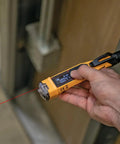 Non Contact Voltage Tester Pen 12 To 1000V AC With Built In Laser Distance Measure LED Alerts And Audible Alarms Pocket Clip For Quick Safe Electrical Checks On Cables Breakers And Outlets in hand