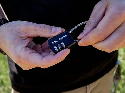 Small Stainless Steel Combination Cable Lock For Overland Truck Racks Custom Combo Code in a user's hand.