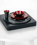 360 Degree Motorized Rotating Display Stand For Photography Products showcasing red and black dishware set on a smooth spinning platform.