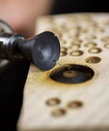 Close-up of Concave Eye Cutter Set For Wood Carving, 8 Pcs Eye Detail Bits creating texture on wood with die grinder.