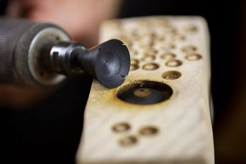Close-up of Concave Eye Cutter Set For Wood Carving, 8 Pcs Eye Detail Bits creating texture on wood with die grinder.