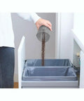 Person emptying dirt bowl of a Cordless Handheld Vacuum For Cars And Home Fast Clean, 2Ah Battery, Icy Blue model into trash bin.