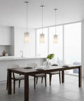 Modern kitchen with One Light Pendant Light With Clear And Frosted Glass Shade above dining table, brushed nickel finish