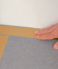 Applying Rug Traction Anti Slip Rubber Tape With Adhesive Backing on corner of a carpet for enhanced grip and curl prevention.