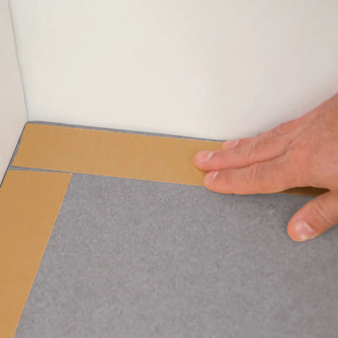 Applying Rug Traction Anti Slip Rubber Tape With Adhesive Backing on corner of a carpet for enhanced grip and curl prevention.