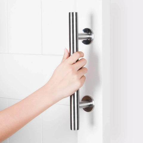 Hand gripping a Two Pack 12 Inch Sliding Barn Door Handle Set, Heavy Duty Stainless Steel Flush Pull Hardware on a white door.