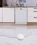 Smart Water Leak Detector 2 Pack With WiFi Alerts And 75 DB Alarm For Instant App Notifications Battery Included Easy Wire Free Design in kitchen on tile floor.