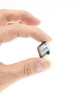 Hand holding Lit Tiny M10SD 10Hz FPV GPS Compass Module for RC Drones, ultra lightweight 18mm square 4.8g UBX M10 GNSS chip.