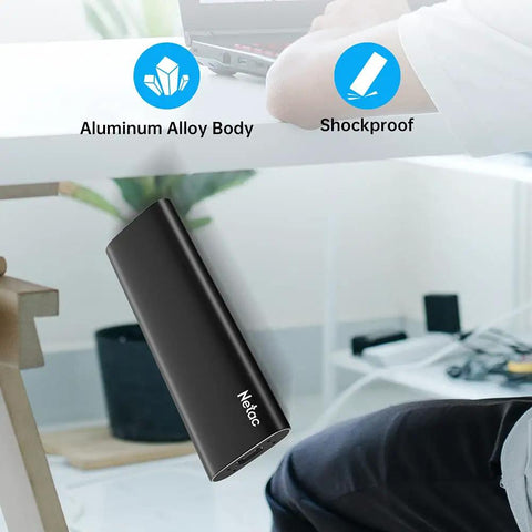 Person using a laptop with 250GB Portable SSD USB 3.2 Gen 2 Type-C External Drive, Slim Aluminum, Shockproof design in foreground.
