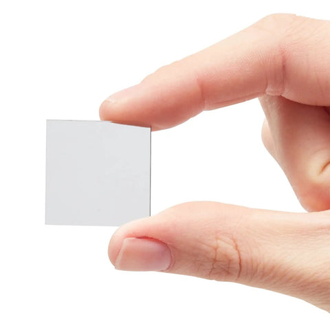 Hand holding a single 1x1 inch mini square mirror tile from 120 Pack Mini Square Mirror Tiles 1x1 Inch For Mosaic Art And Crafts, DIY Home Decor Backsplash.