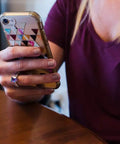 Woman holding phone, wearing a ring with invisible ring size adjuster for loose rings with six sizes keeps your engagement and wedding rings snug and in place no more slips clear ring band sizer guard for loose jewelry multipack ten count.