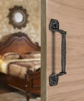Four Pack Cast Iron Sliding Barn Door Handles 5.51 Inch Dark Brown Vintage Metal Pulls on wooden door in bedroom