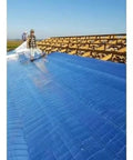 Workers installing Four By Two Hundred Fifty Foot Synthetic Roof Underlayment Pro Grade Heavy Slick Roll on a roof.