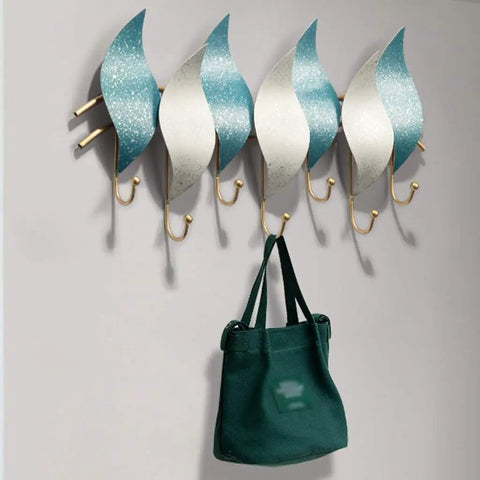 Heavy Duty Wall Mounted Coat Hook With Snowflake Design Iron Wall Hook For Entryway And Bathroom Rust Resistant Metal Hanger For Scarves Umbrellas Bags Keys And Hats Single Unit Silver Finish Home Decor Space Saver displaying a green bag.