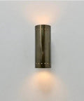 Perforated Brass Wall Sconce - Modern Cylinder Lamp shown mounted, featuring a sleek cylindrical brass design and ambient glow.